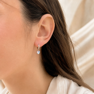 The Afterglow Heart Earrings worn on the ear