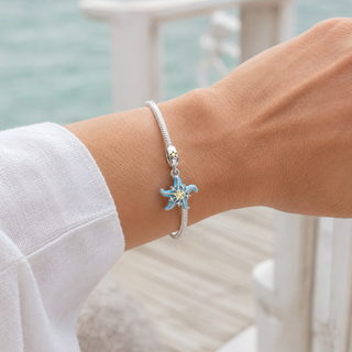 Blue Starfish charm worn on a silver bracelet at realistic scale