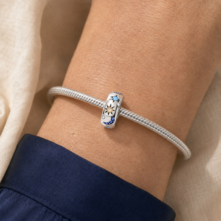 The Celestial Path Spacer Charm worn alone on a silver snake-chain bracelet