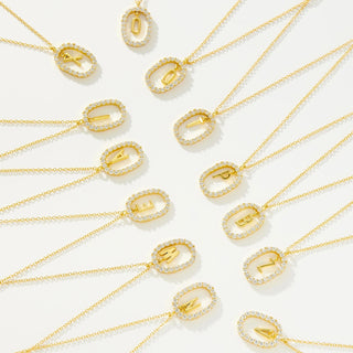 Gold initial necklaces with removable letter pendants flatlay