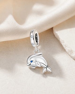 The Silver Dolphin Charm story image on ivory silk and pale stone