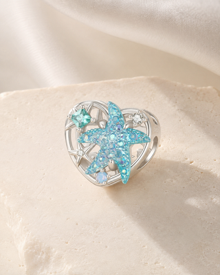 The Starfish Heart Charm story image on ivory silk and pale stone