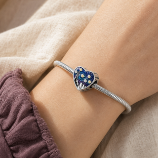 The Dreamer's Night Heart Charm worn on a silver charm bracelet