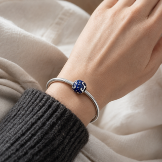 The Midnight Sky Charm worn on a silver charm bracelet
